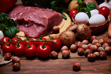 Close view at vegetables and raw meat on a burlap