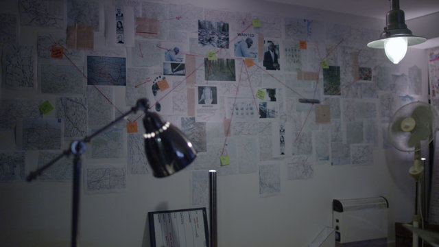  Interior police incident room featuring crime wall with pictures of suspects