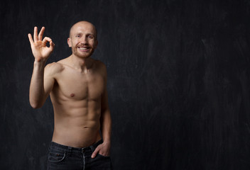 Laughing Sporty and healthy man with strong  press  showing okay