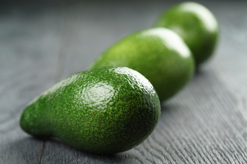 ripe green avocados on wood table