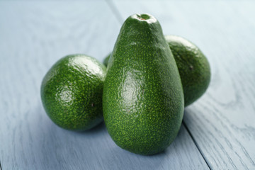 ripe green avocados on blue wood table