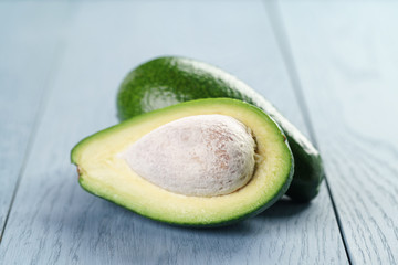 ripe green avocado on blue wood table