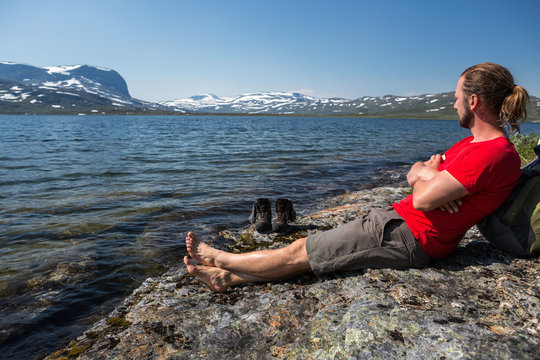 Wanderer macht eine Pasue an einem Bergsee im Schwedischen Fj&auml;ll im Sommer