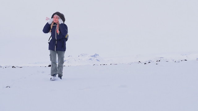 Woman walking in the snow, enjoying winter holidays in the mountains of Iceland. Full HD Video 1920x1080