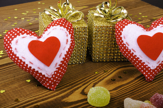 Red hearts, two golden gift and fruit candy.