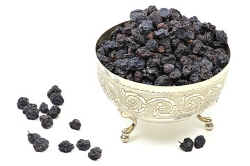 getrocknete Aroniabeeren in einer Silberschale isoliert auf weißem Hintergrund