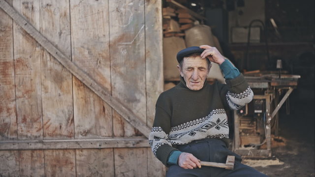Old carpenter at his studio on a sunny day