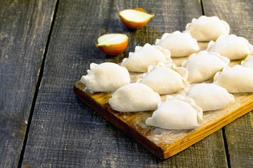 Raw dumplings with potatoes and onions on a table, place for tex