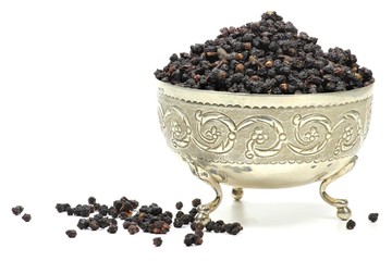 getrocknete Holunderbeeren in einer Silberschale isoliert auf weißem Hintergrund