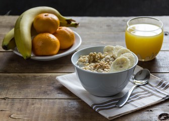 oatmeal with bananas and nuts and orange juice and fruit