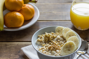 oatmeal with bananas and nuts and orange juice and fruit