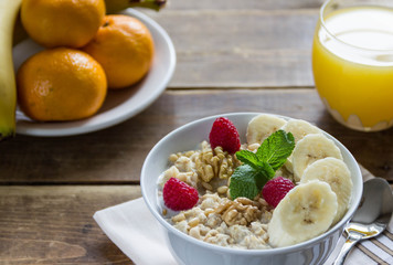 oatmeal with bananas and nuts and orange juice and fruit