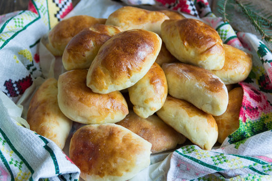 Russian pirozhki (baked patties) on wooden cutboard