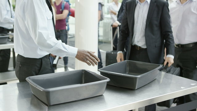 Airport security guards on duty, searching passengers before a flight