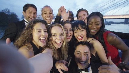 Happy diverse group of friends at black tie event, pose to take a selfie