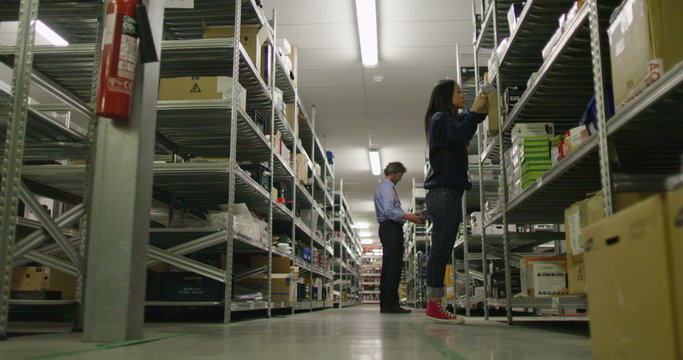 Workers in a warehouse or factory checking stock and preparing deliveries