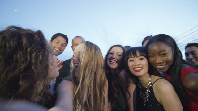  Happy diverse group of friends at black tie event, pose to take a selfie