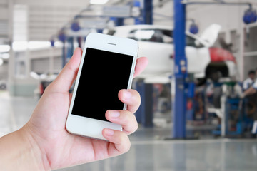 hand hold smartphone with auto tire repair services blurred back