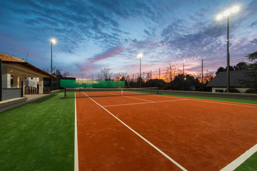 Tennis court at a private estate in the twilight and magic sky - obrazy, fototapety, plakaty
