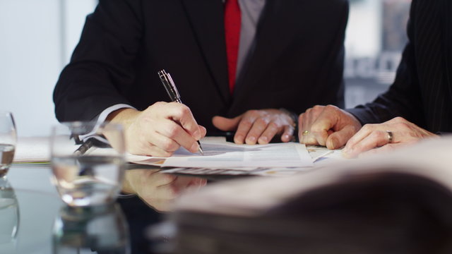  Businessman signs a contract and shakes hands on the deal.