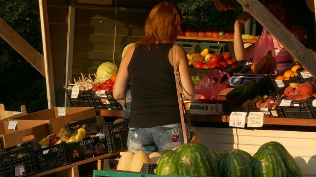 Ungraded: A woman buys fruit at a stall summer day outdoors.

Source: Lumix DMC, ungraded H.264 from camera without re-encoding.