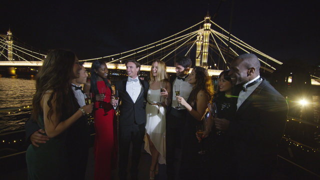  Happy diverse group of friends socializing at boat party on the River Thames