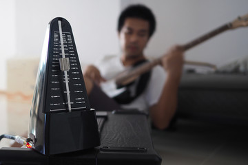 Black metronome is used by musician to help keep a steady tempo as he play, or to work on issues of...