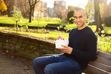Obraz premium young man enjoying a take-away in the park