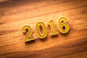 2016 year golden number on wooden background. New year decoration.