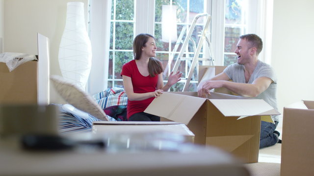  Happy young couple unpacking boxes, moving into new home