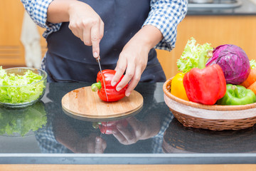 Female cook cutting bell pepper