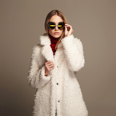 beautiful winter girl in white fur and sunglasses. winter fashion 
