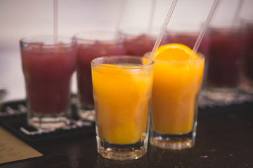 Beautiful row line of different colored alcohol cocktails with mint on a christmas party, martini, vodka with bubbles, wine and others on decorated catering bouquet table on open air event, picture 