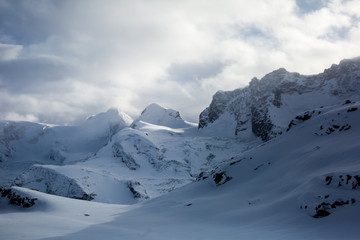 Amazing view on Matterhorn - famous mountain in Swiss Alps, with aerial view on Zermatt Valley, Switzerland, in a sunny winter day, with blue sky, clouds and view on ski resort
