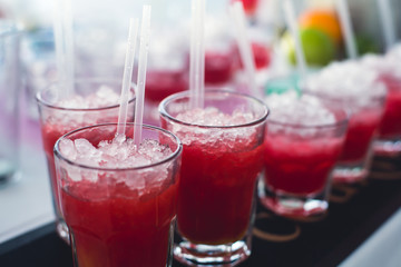Beautiful row line of different colored alcohol cocktails with mint on a christmas party, martini, vodka with bubbles, wine and others on decorated catering bouquet table on open air event, picture 