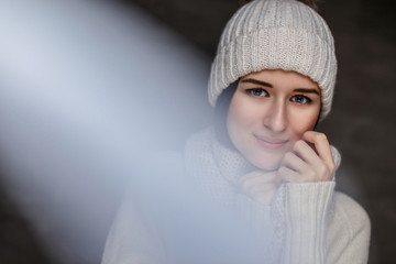  Woman in white sweater and winter hat.