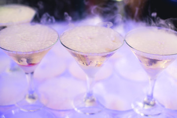 Beautiful row line of different colored alcohol cocktails with mint on a christmas party, martini, vodka with bubbles, wine and others on decorated catering bouquet table on open air event, picture 