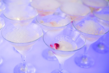 Beautiful row line of different colored alcohol cocktails with mint on a christmas party, martini, vodka with bubbles, wine and others on decorated catering bouquet table on open air event, picture 