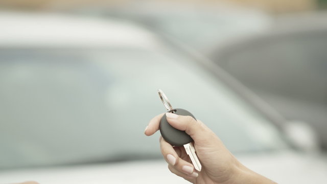  close up of hands giving keys to a new car