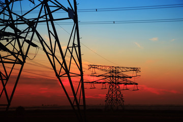 The silhouette of the evening electricity transmission pylon