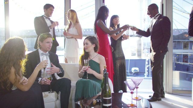  Attractive diverse group of friends socialising at elegant party on a boat