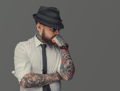 Man with tattooed arms thinking.
