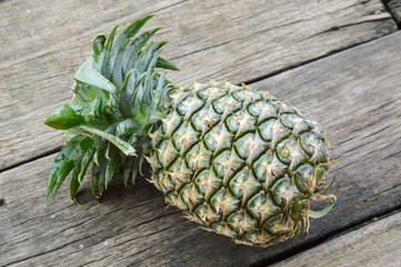 fresh green pineapple on wood plank
