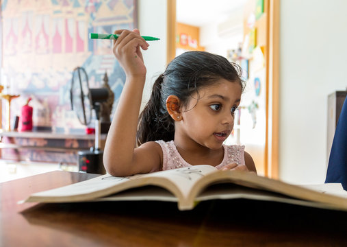Indian girl reading book at home