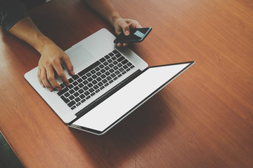 top view of businessman hand using on smart phone and laptop com