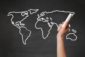 Adult drawing world map on chalkboard