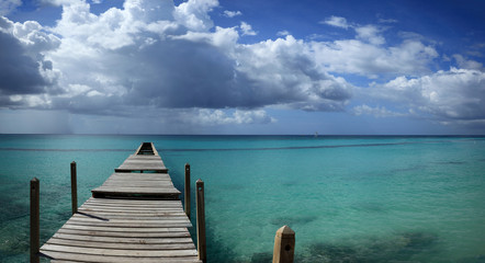 panoramique sur ponton d'embarquement et orage tropical au loin sur la mer des Caraïbes