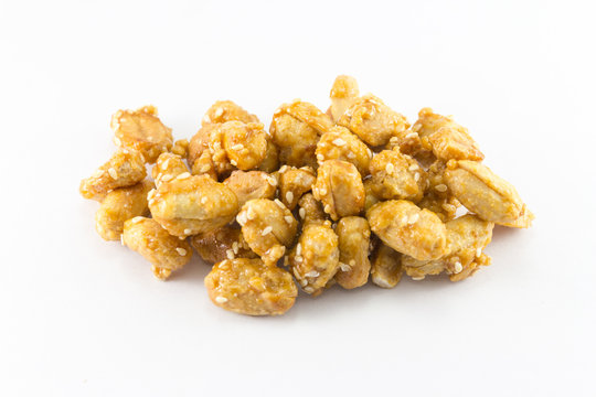 Peanuts in caramel with sesame seeds on white background