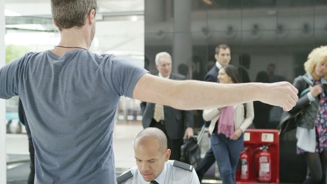  Airport security guards on duty, searching passengers before a flight
