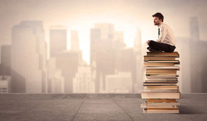 Man sitting on books in the city